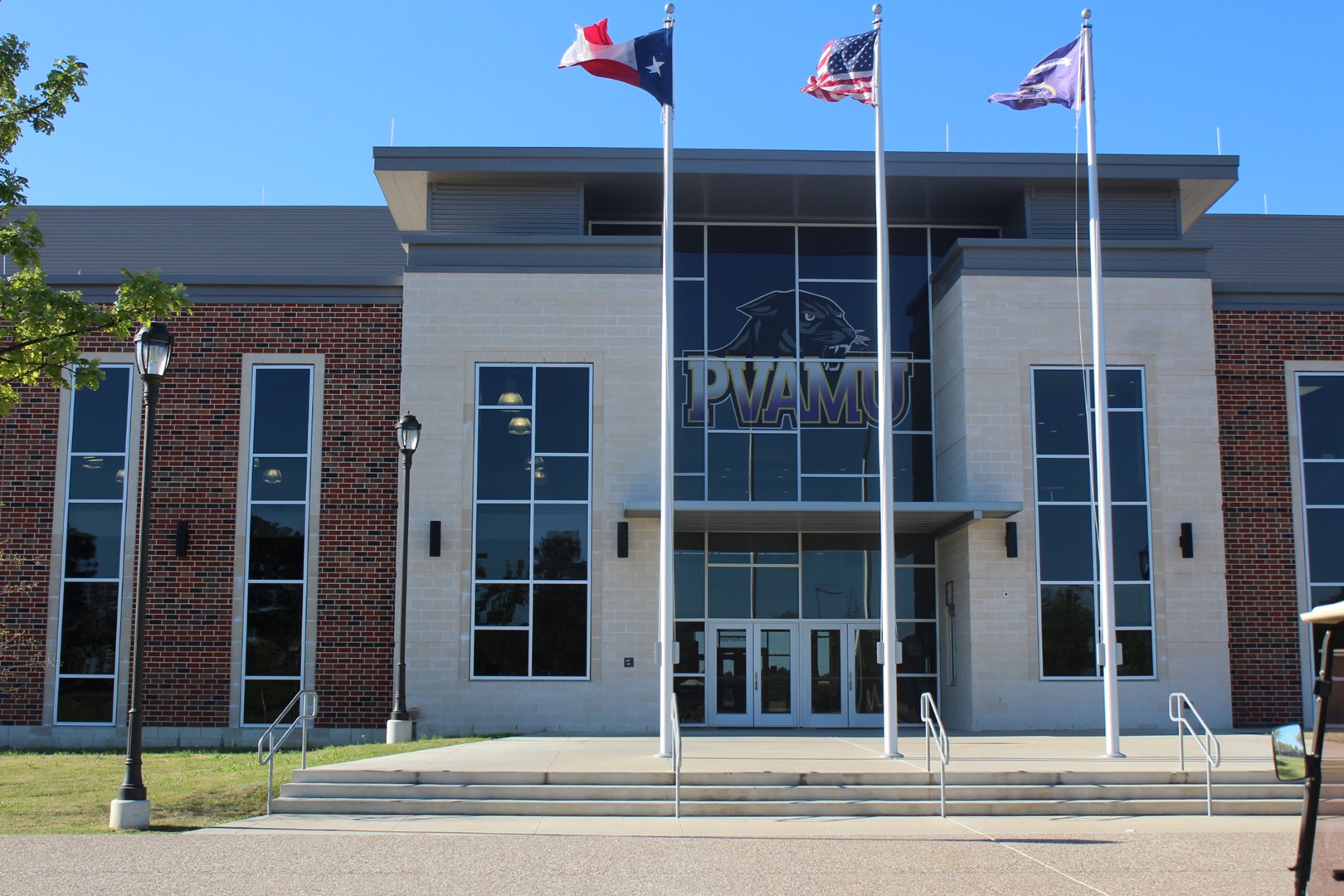 entryway to welcome center at PVAMU and three flag poles